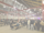 outdoor covered space with lots of people standing and sitting at benches