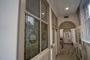 A corridor with internal stained glass windows on the left